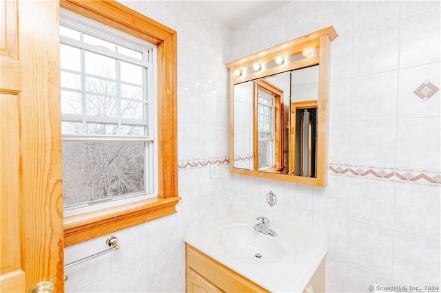 bathroom with a wealth of natural light, tile walls, and vanity