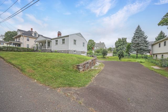 view of home's exterior featuring a lawn, covered porch, and a garage