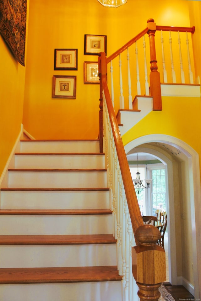 stairs with a chandelier