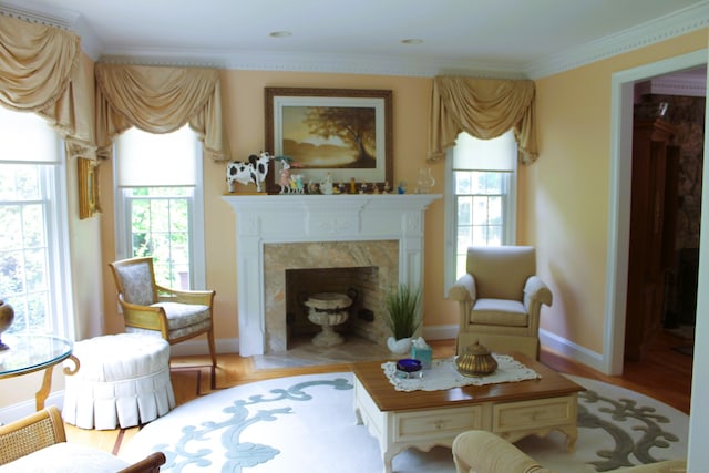 living room with light hardwood / wood-style flooring, a high end fireplace, and ornamental molding