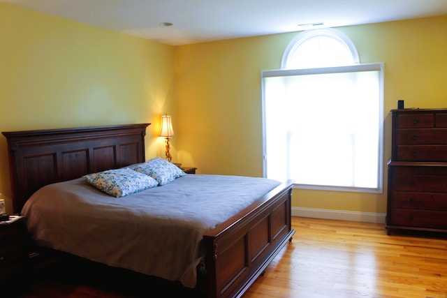 bedroom featuring light hardwood / wood-style floors and multiple windows