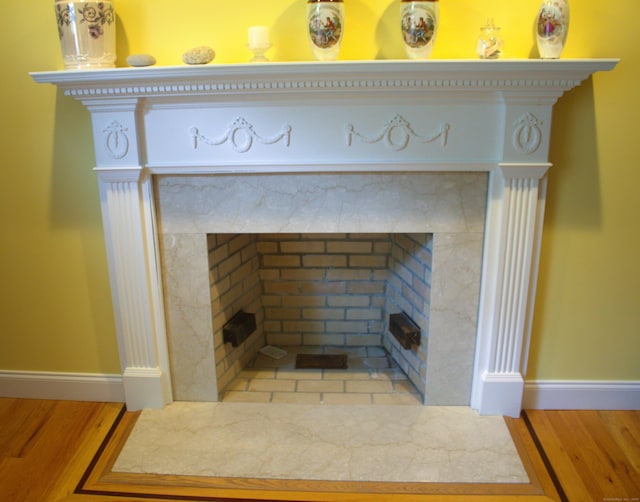 room details with hardwood / wood-style floors and a premium fireplace