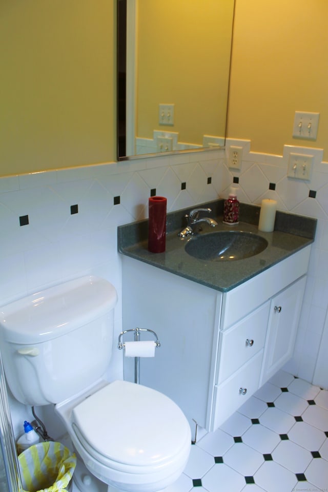 bathroom featuring tile patterned floors, toilet, vanity, and tasteful backsplash