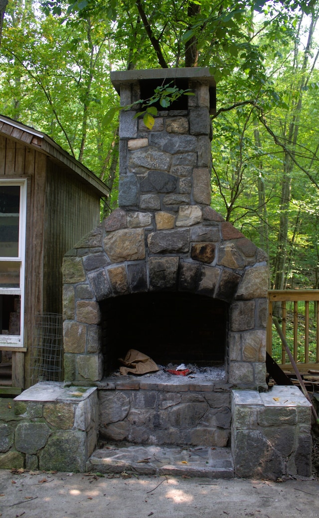 details featuring wooden walls and an outdoor stone fireplace