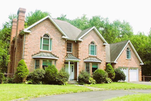 view of property with a garage and a front lawn