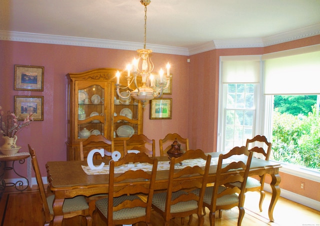 dining area with a chandelier, ornamental molding, and hardwood / wood-style flooring