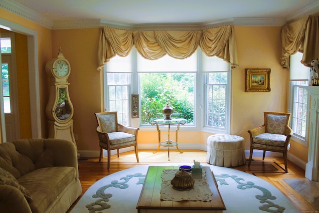 sitting room with a wealth of natural light, hardwood / wood-style flooring, and crown molding