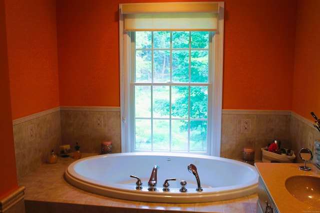 bathroom with tiled tub and vanity