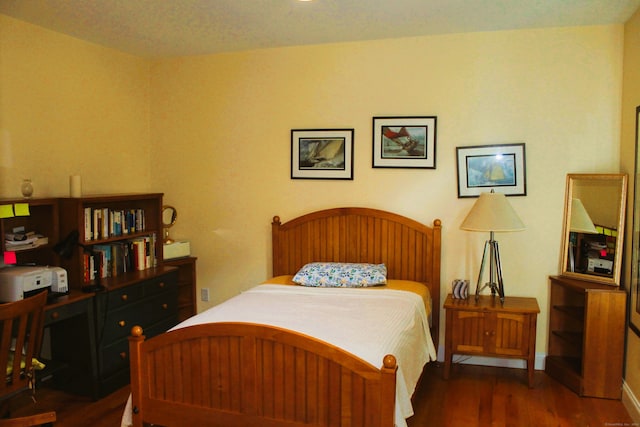 bedroom with dark hardwood / wood-style flooring