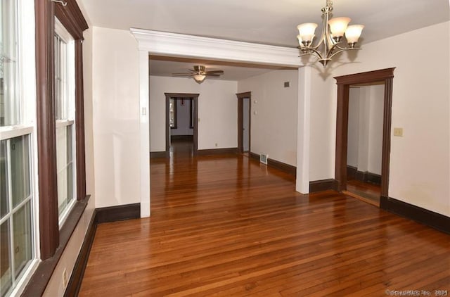 interior space with ceiling fan with notable chandelier and dark wood-type flooring