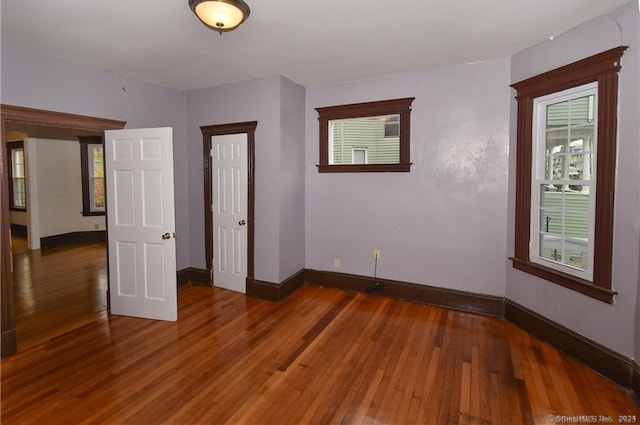 unfurnished bedroom featuring multiple windows and hardwood / wood-style flooring