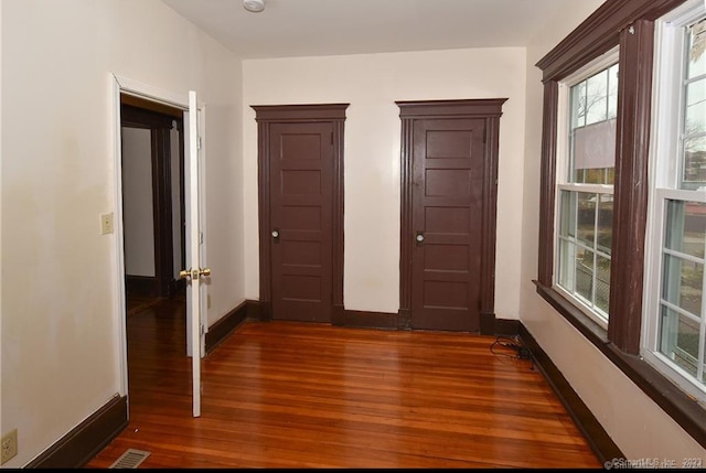 corridor with hardwood / wood-style flooring