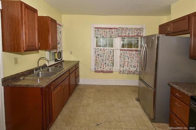 kitchen featuring light tile patterned flooring, sink, and stainless steel refrigerator