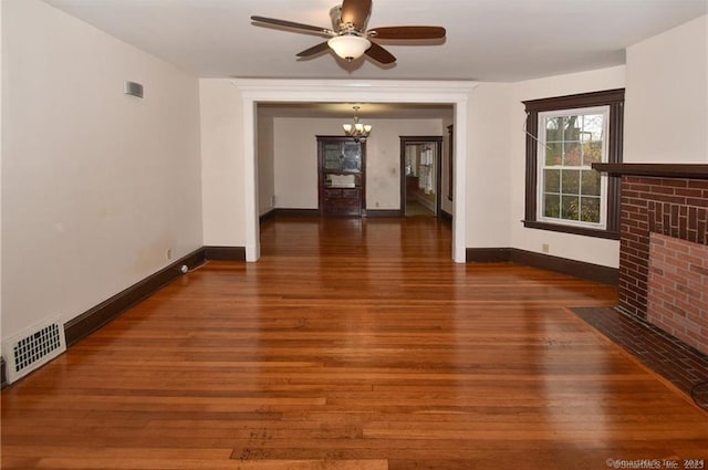 unfurnished living room featuring a fireplace, dark hardwood / wood-style flooring, and ceiling fan with notable chandelier