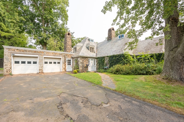 view of front of house with a garage and a front lawn