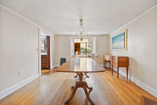 dining room with light wood-type flooring, an inviting chandelier, ornamental molding, and radiator