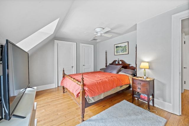 bedroom with ceiling fan, vaulted ceiling, and light hardwood / wood-style floors