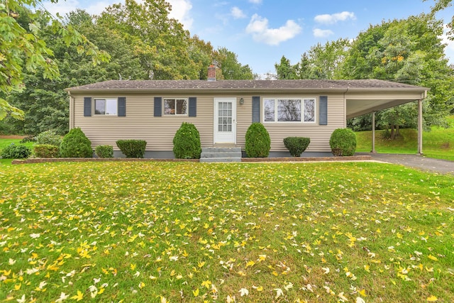 ranch-style home featuring a carport and a front lawn