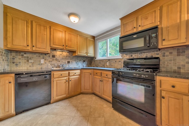 kitchen with sink, light tile patterned floors, tasteful backsplash, black appliances, and dark stone counters