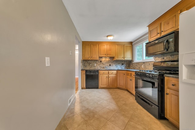 kitchen with backsplash, light tile patterned floors, black appliances, and sink