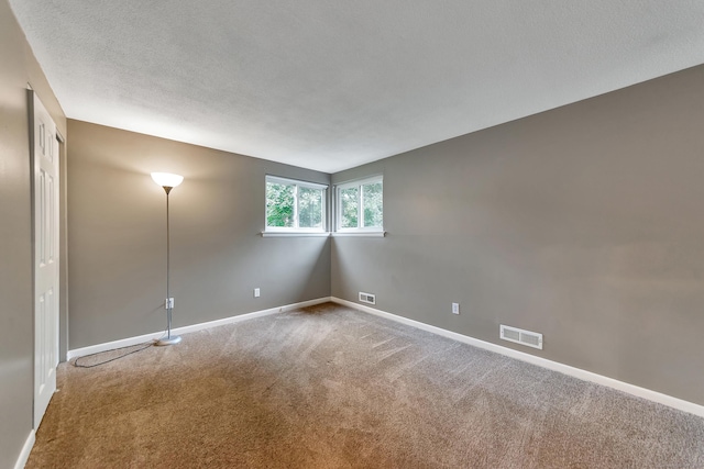 spare room with carpet floors and a textured ceiling