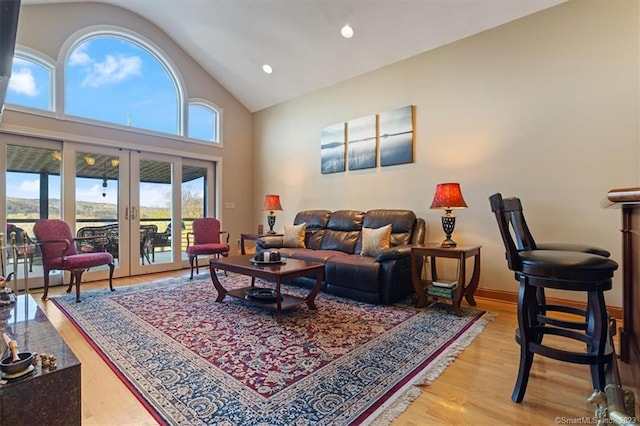 living room featuring french doors, high vaulted ceiling, and wood-type flooring