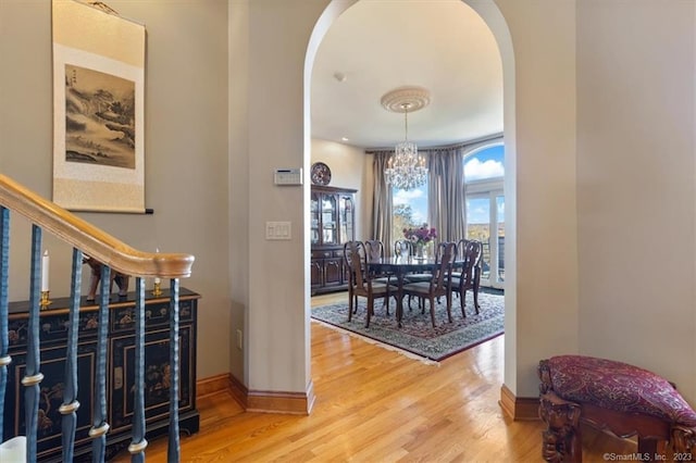 hallway featuring hardwood / wood-style flooring and a chandelier