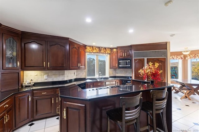 kitchen featuring light tile patterned floors, a healthy amount of sunlight, a center island, and backsplash