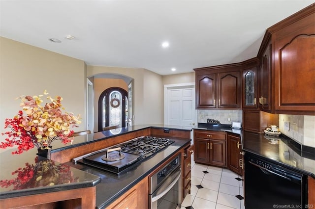 kitchen with tasteful backsplash, dishwasher, stainless steel oven, and light tile patterned flooring