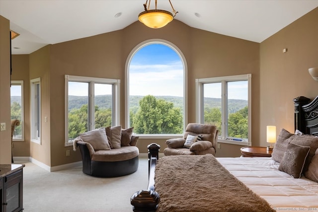 bedroom featuring multiple windows, light colored carpet, a mountain view, and vaulted ceiling