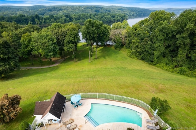 view of swimming pool featuring a yard and a water view