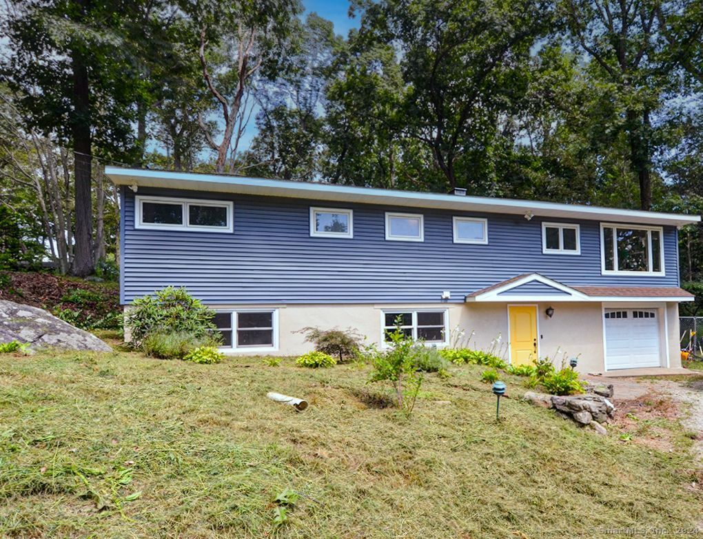 15 Wakerobin Rd, Norwalk, CT 06851 - view of front facade with a front yard and a garage