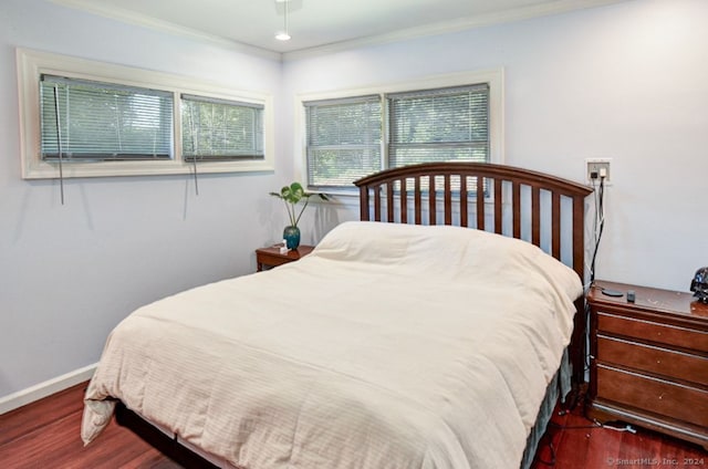 bedroom featuring ornamental molding and dark hardwood / wood-style flooring