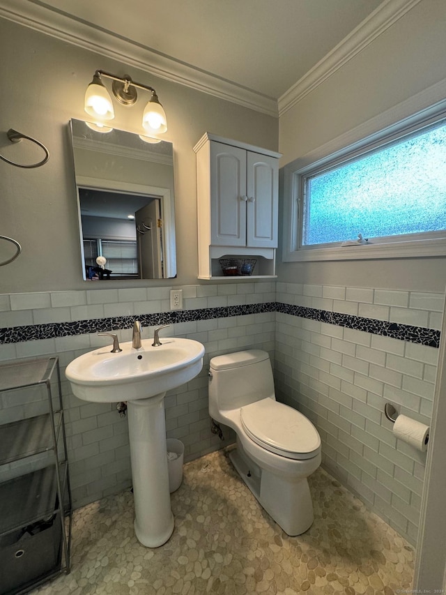 bathroom featuring toilet, tile walls, and crown molding