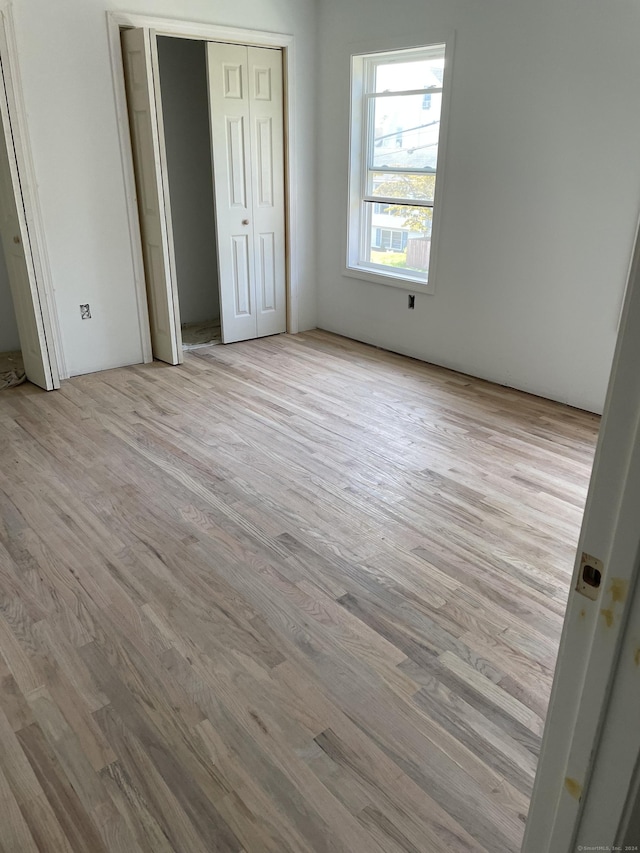 unfurnished bedroom featuring wood finished floors and a closet