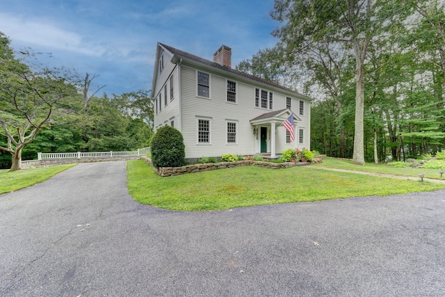 colonial home featuring a front lawn