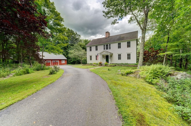 colonial house featuring a front lawn