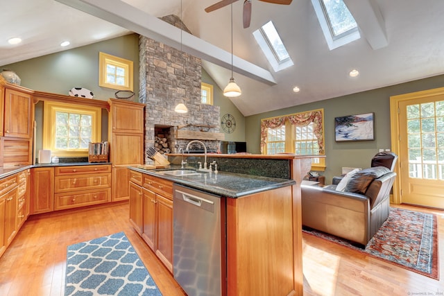 kitchen featuring a kitchen island with sink, light hardwood / wood-style floors, sink, dishwasher, and pendant lighting