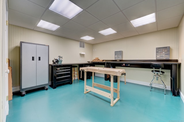 office space featuring a paneled ceiling and a workshop area