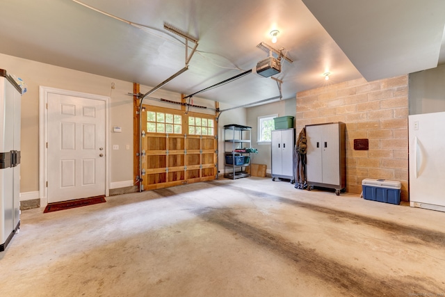 garage with a garage door opener and white refrigerator