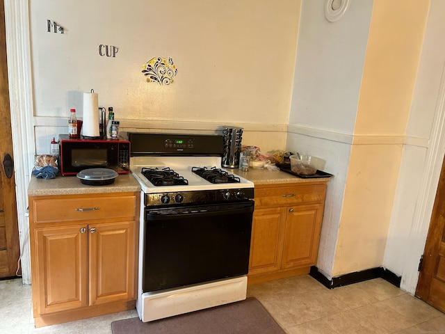 kitchen with gas range gas stove and light tile patterned floors