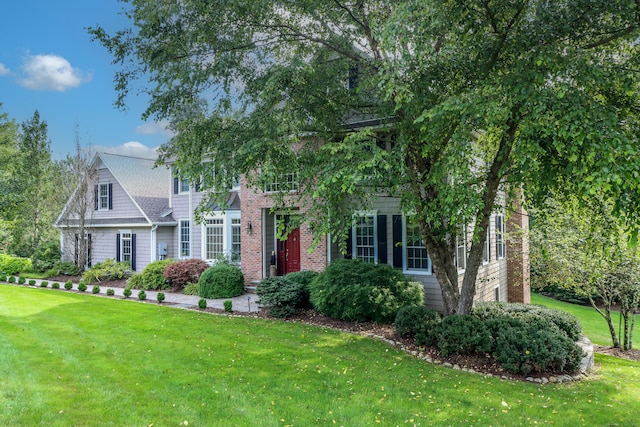 view of property hidden behind natural elements with a front yard