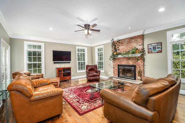 living room with ornamental molding, a fireplace, light wood-type flooring, ceiling fan, and brick wall