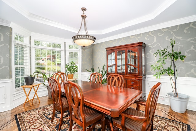 dining space featuring a raised ceiling and crown molding