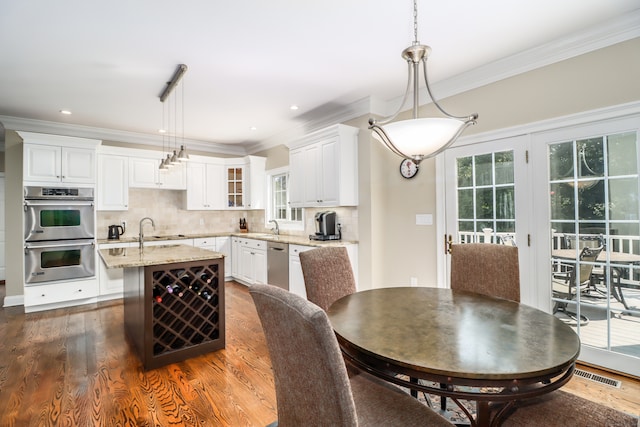 dining room featuring sink, crown molding, and hardwood / wood-style floors