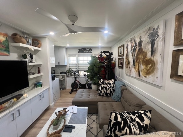 living room featuring ceiling fan, crown molding, and light hardwood / wood-style floors