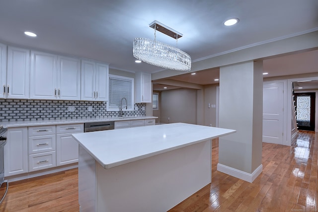 kitchen featuring pendant lighting, white cabinetry, light wood-type flooring, and tasteful backsplash