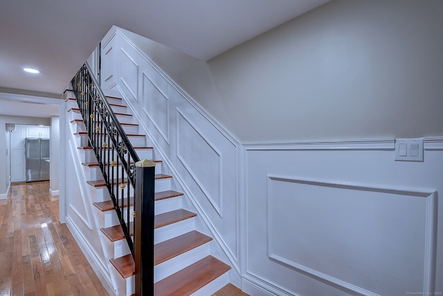 stairs featuring hardwood / wood-style floors