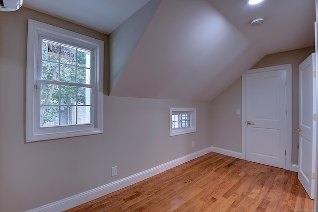 additional living space featuring light hardwood / wood-style floors and lofted ceiling