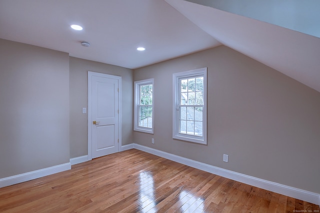 bonus room with vaulted ceiling and light hardwood / wood-style flooring